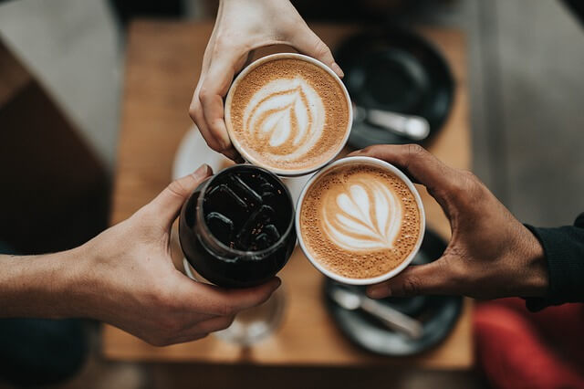 A group of people holding cups with coffee in them.