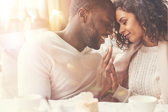 A man and woman are sitting in bed together.